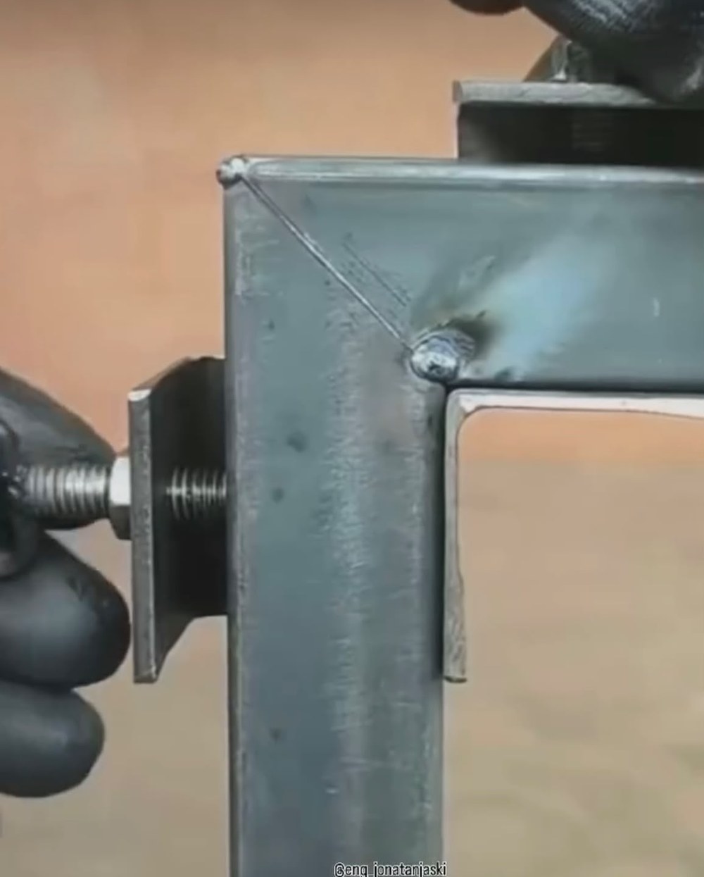 Gabarito de bancada travando o esquadro de uma estrutura durante a soldagem.